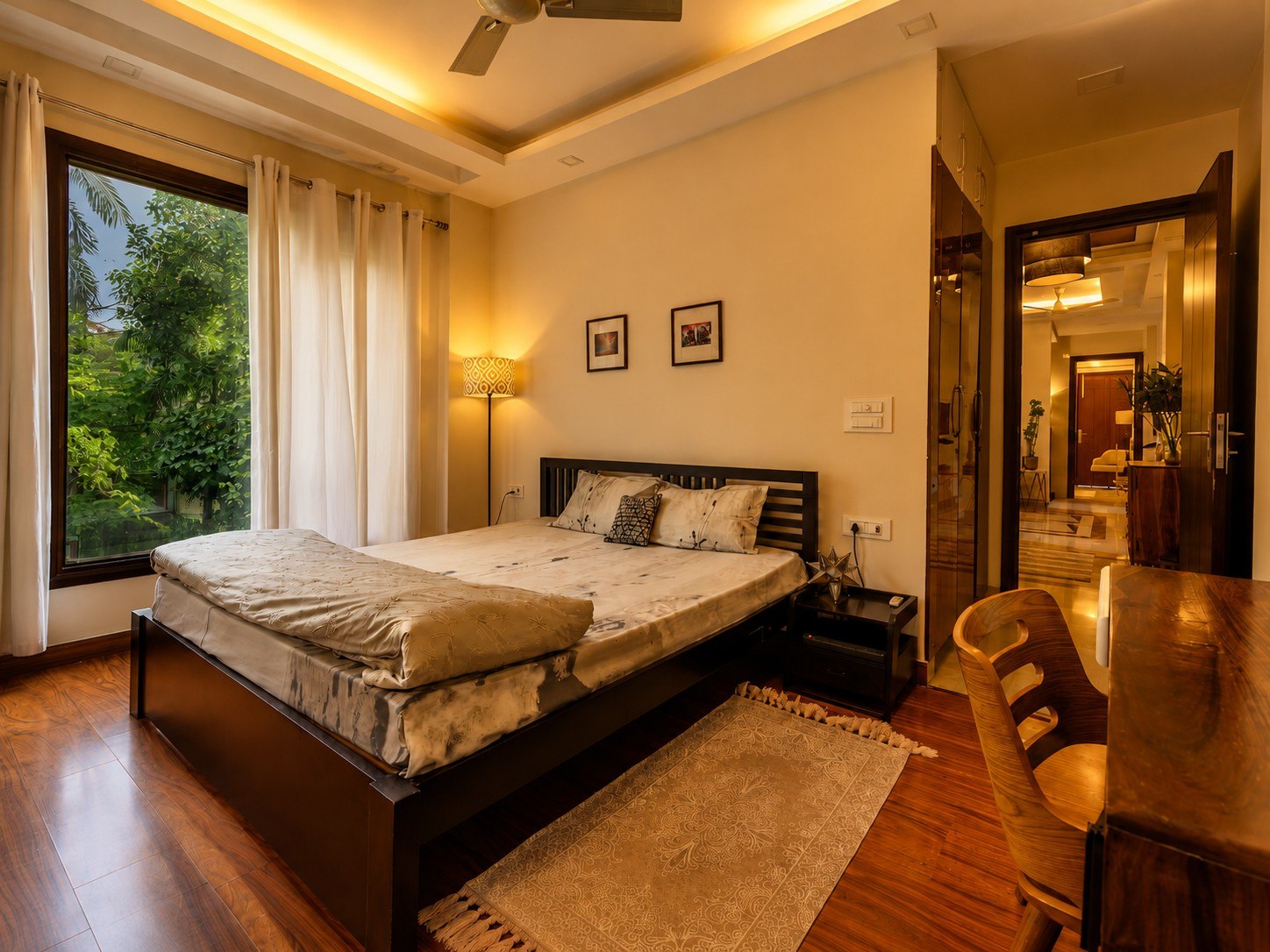Comfortable bedroom with large windows and greenery views.