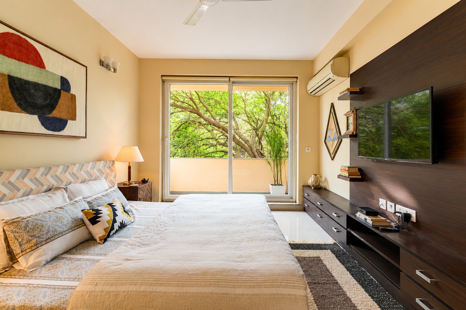 Bright bedroom with a large green-facing window and television wall.