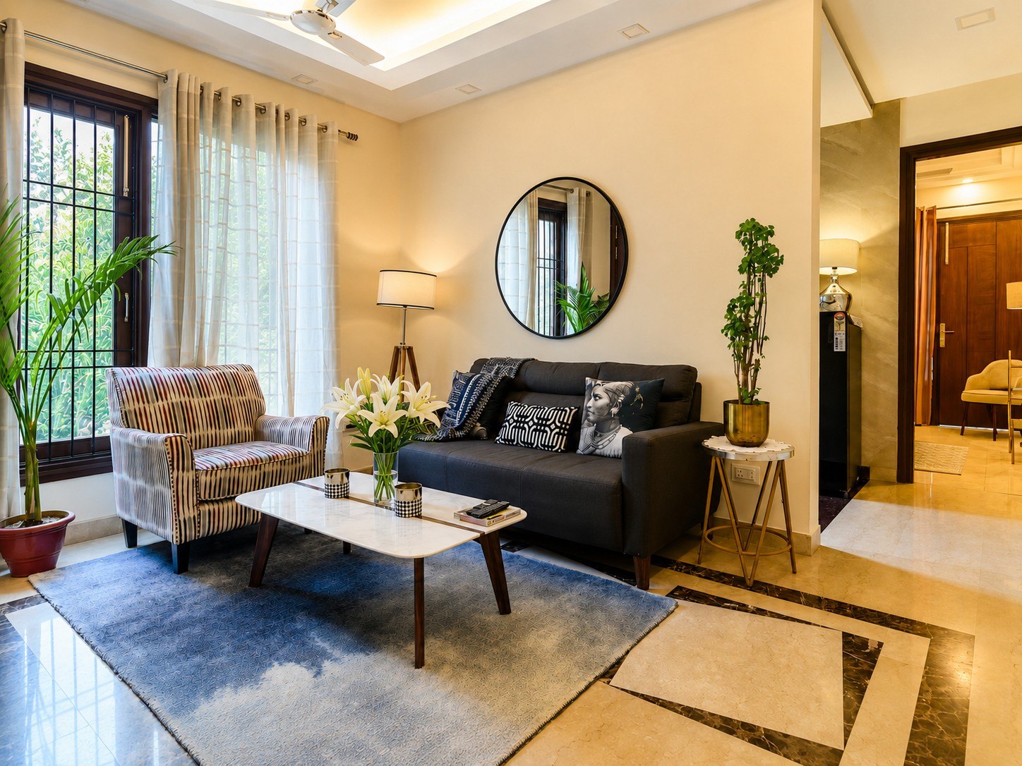 Living area with sofa seating, a coffee table, plants, and a mirror.