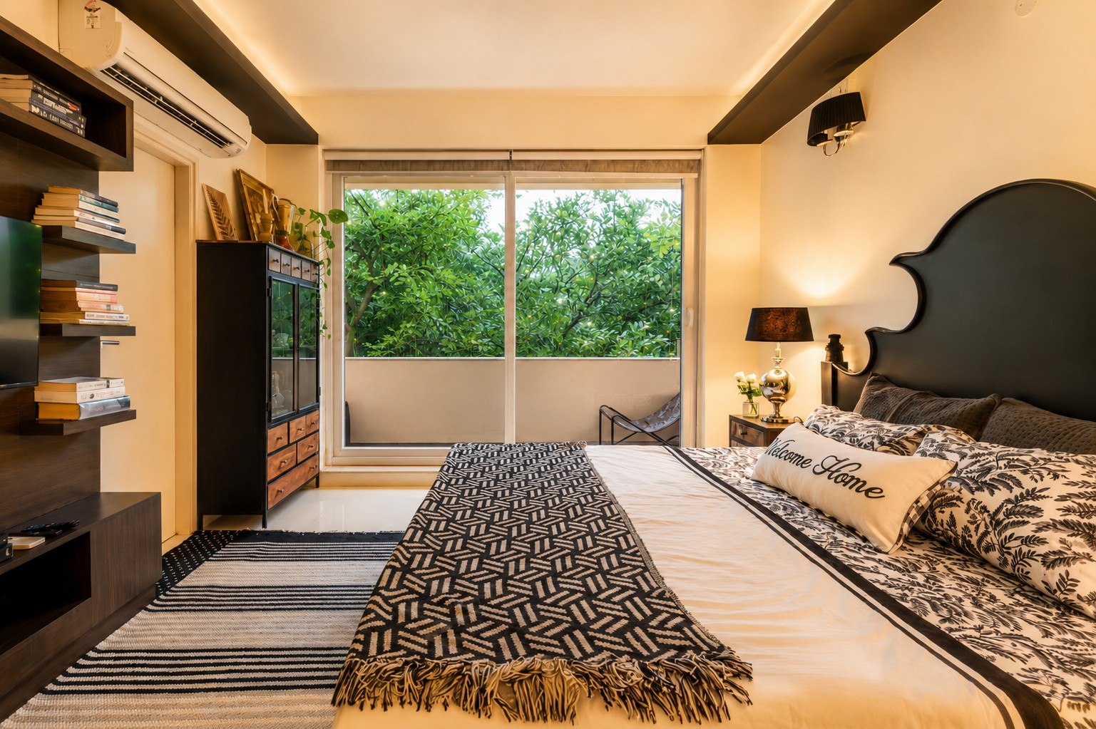 Bedroom view with media wall, bed, and green outlook.
