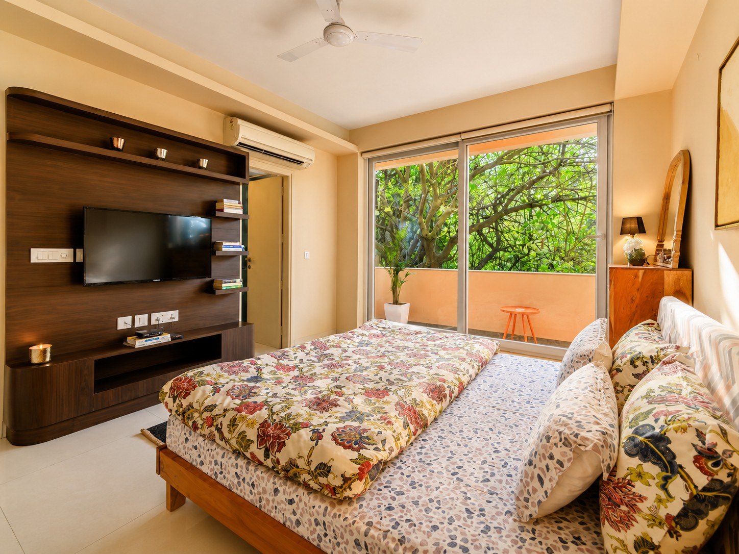 Bedroom with patterned bedding, wardrobes, and soft window light.