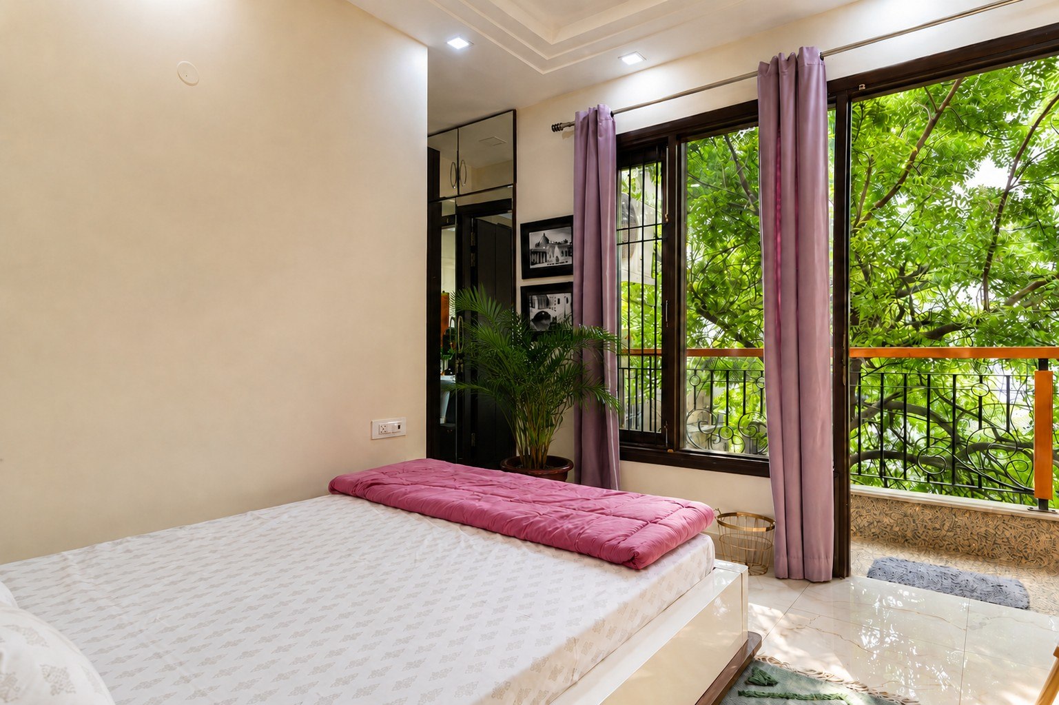 Alternate view of the bedroom and its balcony or green outlook.