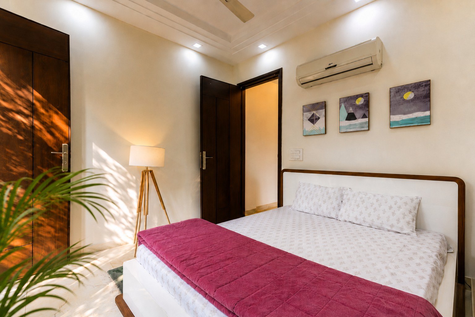 Additional sleeping-space view with pale bedding and framed artwork.