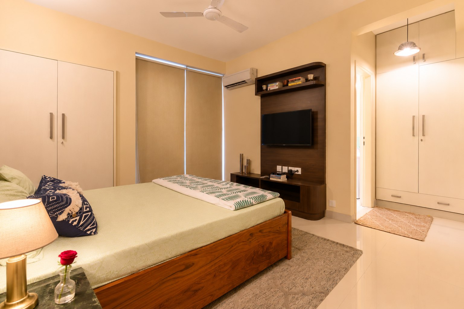 Shared living area with sofas, television, plants, and daylight.